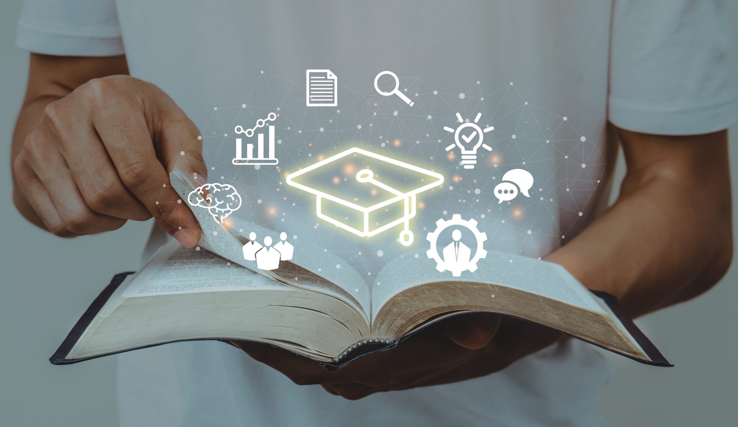 A man holding an open book with learning icons, illustrating how to develop leadership skills.